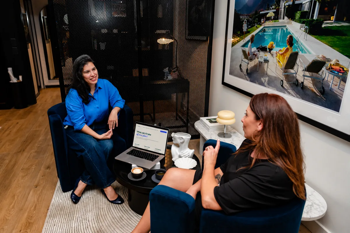 Jane in conversation with another person, with the JA Media AI website displayed on a laptop between them.